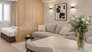 A modern living room with a sofa, a dining table, and a vase of flowers. - Montmartre studio with elevator access (Paris)