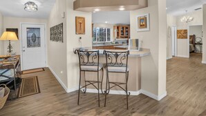Una cucina moderna con angolo bar, mobili in legno e zona pranzo con tavolo e sedie.