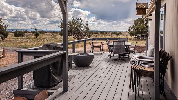 Una terrazza esterna coperta con un braciere, un'area salotto e vista sul paesaggio.