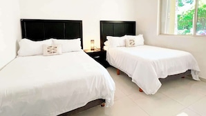 A hotel room with two beds, white bedding, and a nightstand with a lamp. - Family escape with pool & beach acces (Puerto Aventuras)