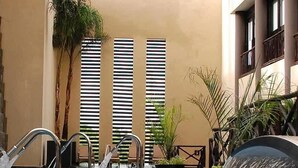 A pool area with multiple water jets, potted plants, and a seating area. - Beachside Condo w/ Private Terrace & 2 Pools (Puerto Aventuras)