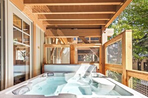 Un jacuzzi con cubierta de madera y vista al exterior.