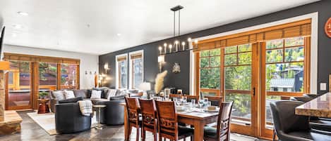 A spacious living area with a dining table set for six, surrounded by comfortable seating.