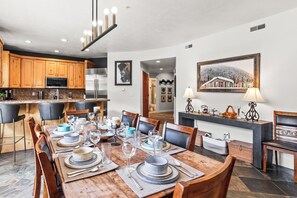 A dining area with a wooden table set for six, surrounded by chairs. - Main Street - Just Steps Away | Private Hot Tub |Managed by Park City Lodging (Park City)