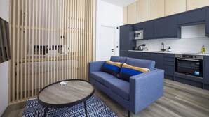A modern kitchen with dark cabinetry, a built-in oven, and a microwave. - Argyl | Abbey Gate: Studio 11 (Edinburgh)