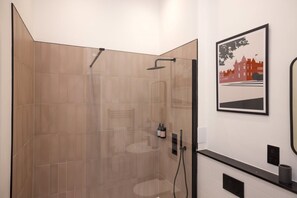 Een douche, handdoeken, shampoo, toiletpapier