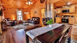 A cozy cabin interior with a living room, dining area, and kitchen. - Secluded 2 Bedroom Timber Ridge Cabin- Hot Tub, Lake Boat Ramp 1 Mile, Fishing (Louisa)