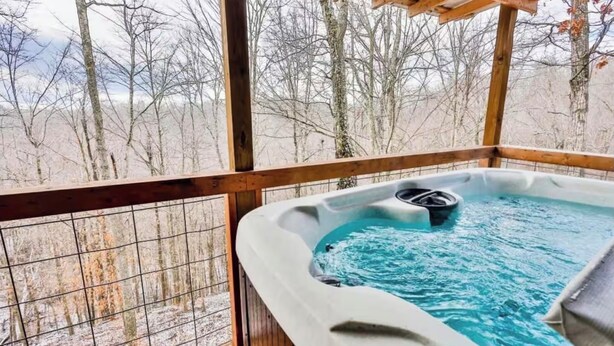 A hot tub on a wooden deck with a view of leafless trees. - Secluded 2 Bedroom Timber Ridge Cabin- Hot Tub, Lake Boat Ramp 1 Mile, Fishing (Louisa)