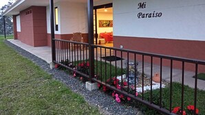 En bygning med et skilt, der viser "Mi Paraíso", og et overdækket udendørs område med siddepladser og en lille have.