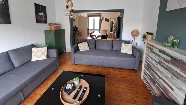 A modern living room with a grey sofa, a black coffee table, and a wooden sideboard. - Vakantiehuis d'Ereplatse (Zuienkerke)