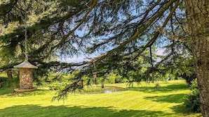 A well-maintained garden with a bird feeder, a small pond, and a clear sky. - Tan Y Bryn Y Beudy, Newport (Dinas Cross)