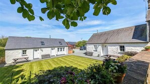 A courtyard with two white buildings, a grassy lawn, and potted plants. - Tan Y Bryn Y Beudy, Newport (Dinas Cross)