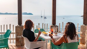 Two people dining at a table with a view of the sea and boats. - Camping Village Rosselba Le Palme Mobilehome Comfort for 4 persons (Portoferraio)