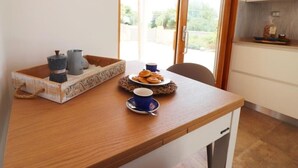 Ein Holztisch mit einer Schale, die eine Tasse, ein Gebäckteller und ein kleines dekoratives Element enthält.