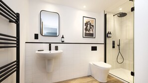 A modern bathroom with a white sink, toilet, and glass shower enclosure. - Argyl | Abbey Gate: Studio 4 (Edinburgh)