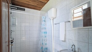 A bathroom with white tiled walls, a wooden ceiling, a shower with a starfish-patterned curtain, a white toilet, a sink with a faucet, and a mirror above the sink. - House w/ 2 Bedrooms 650 m From the Beach Adu0440 (Florianópolis)