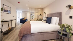 A modern bedroom with a large bed, bedside tables, a desk, and a chair. - Argyl | Abbey Gate: Studio 3 (Edinburgh)