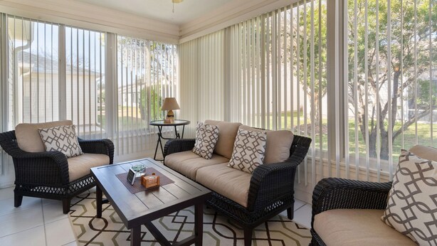 A sunlit room with a sofa, two armchairs, a coffee table, and a ceiling fan. - 3/2 Beautiful Home in Summerhill (The Villages)