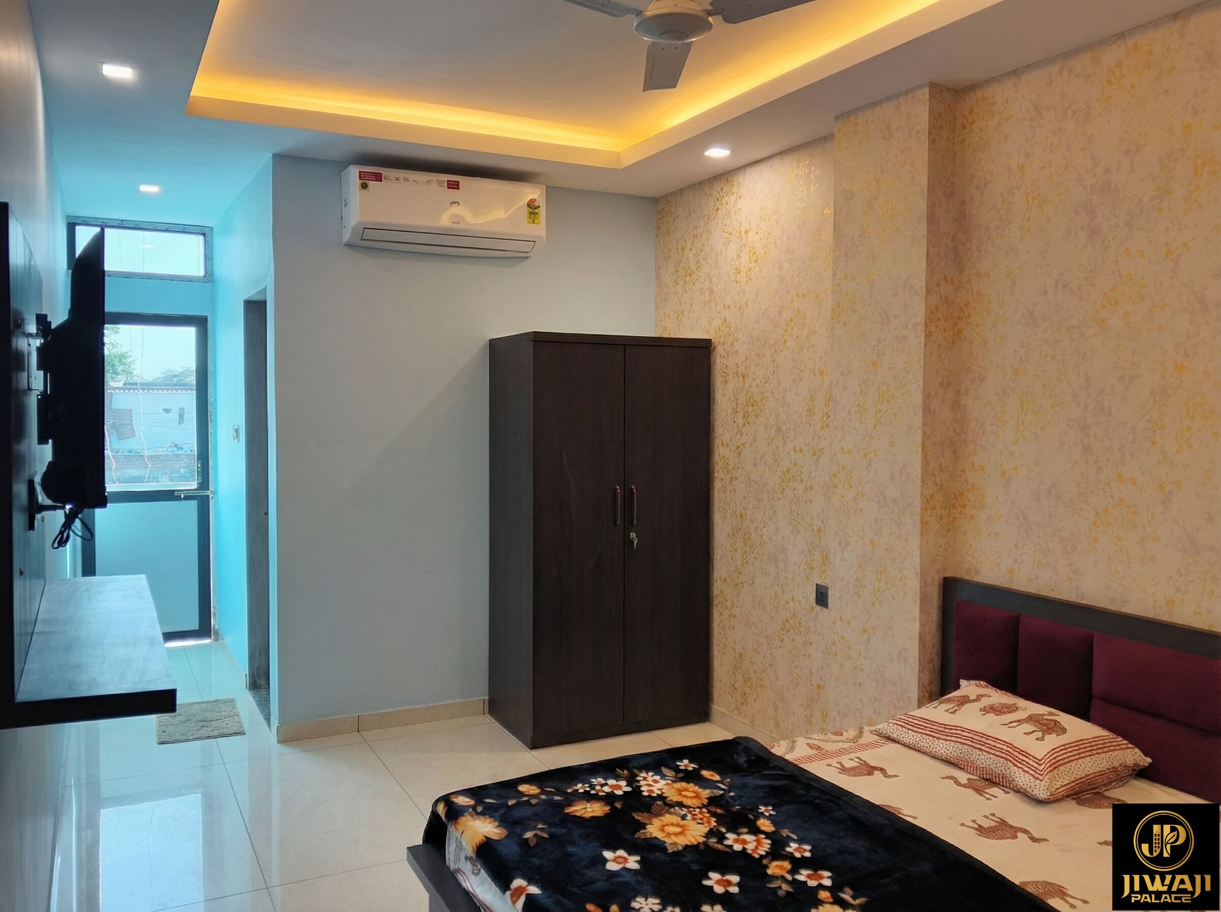 A bedroom with a bed, a wardrobe, an air conditioner, and a window.