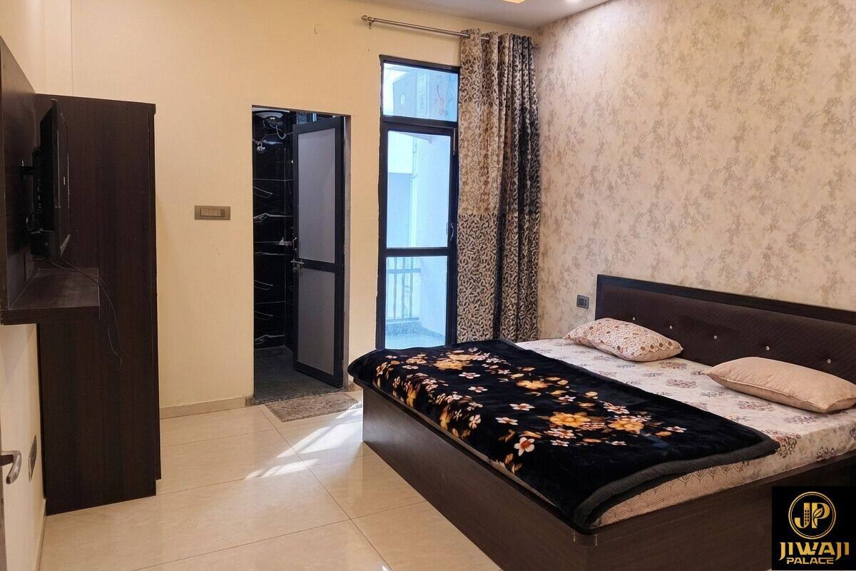 Een slaapkamer met een bed, een kledingkast, een deur en een raam.