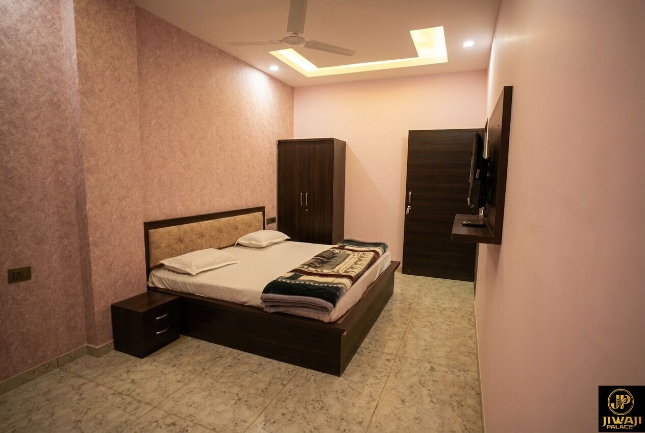 Une chambre à coucher comprenant un lit, une armoire, un téléviseur et un ventilateur de plafond.