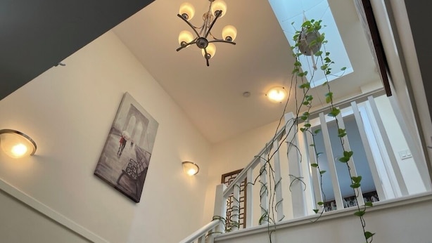 Eine Treppe mit weißen Geländern und einer Kristallleuchtre.