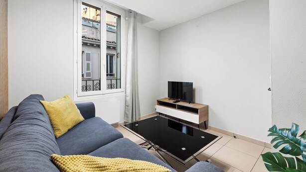 Un soggiorno moderno con un divano, un tavolino da caffè e una TV su un mobile.