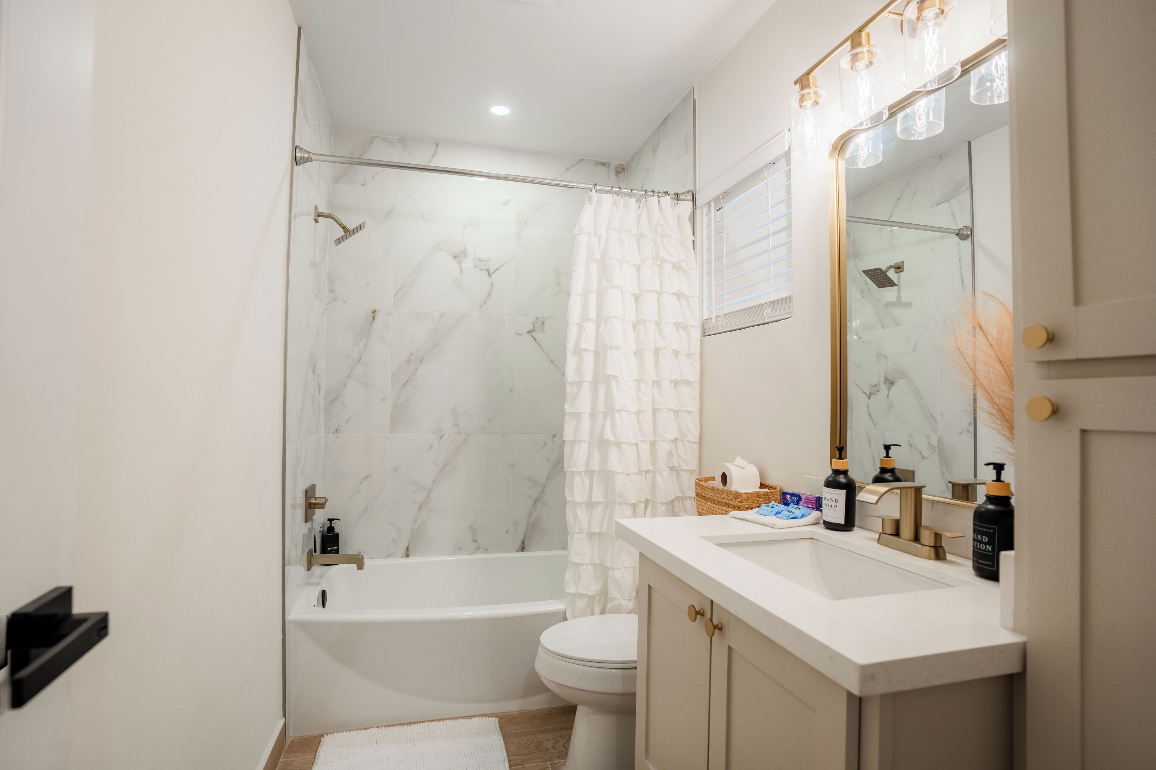 A modern bathroom with a bathtub, toilet, and vanity.
