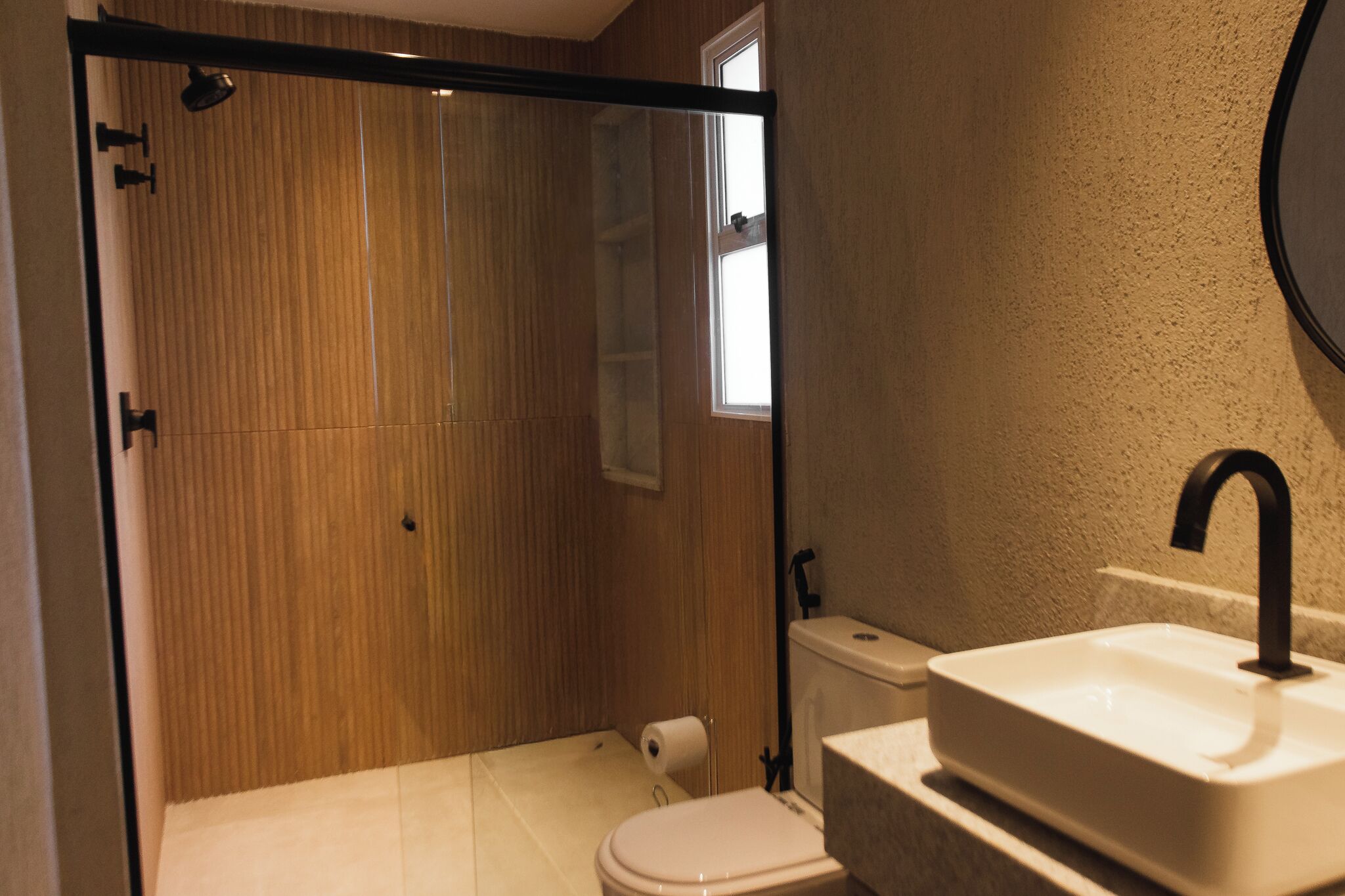 A bathroom with a shower, toilet, and sink.