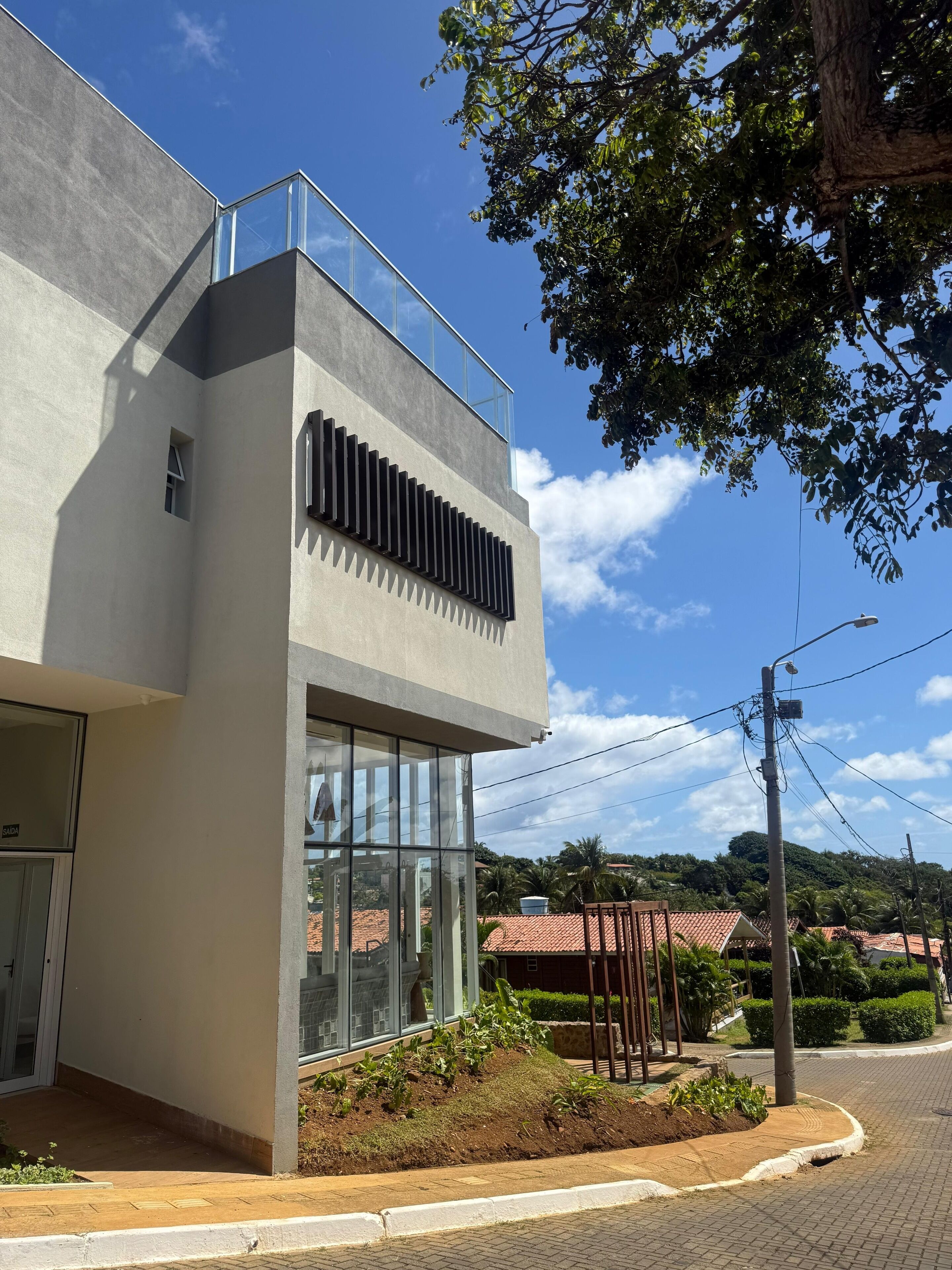 Un edificio moderno con techo plano, ventanas amplias y un balcón.