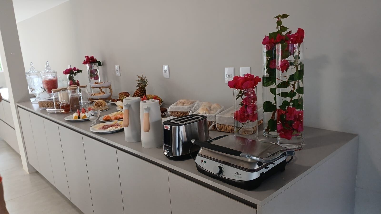 Montaje de bufé con diversas opciones de comida, un tostador y jarrones decorativos.