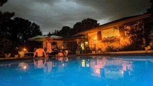 A swimming pool with a house in the background.