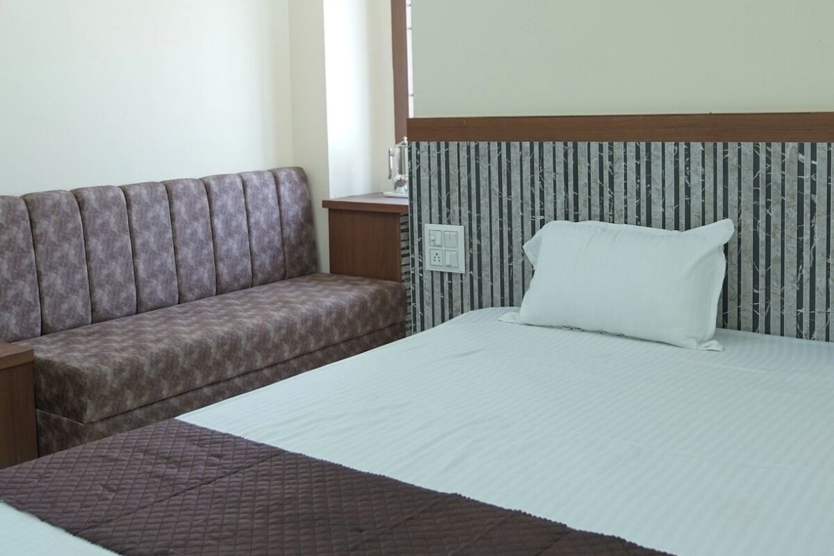 Une chambre d’hôtel avec un grand lit, un canapé et une table de chevet.