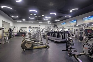 A gym with various cardio machines, weightlifting equipment, and a mirrored wall. - The Palms Destin 2103 (Destin)