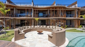 A modern hotel with a pool, outdoor seating, and a multi-story structure. - Apartments in Condo With Pool in Front of the Beach - NVB (Porto de Pedras)