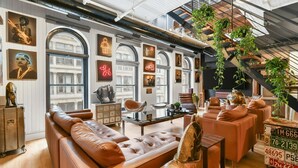 Een moderne woonkamer met leren banken, een salontafel en een wenteltrap met planten.
