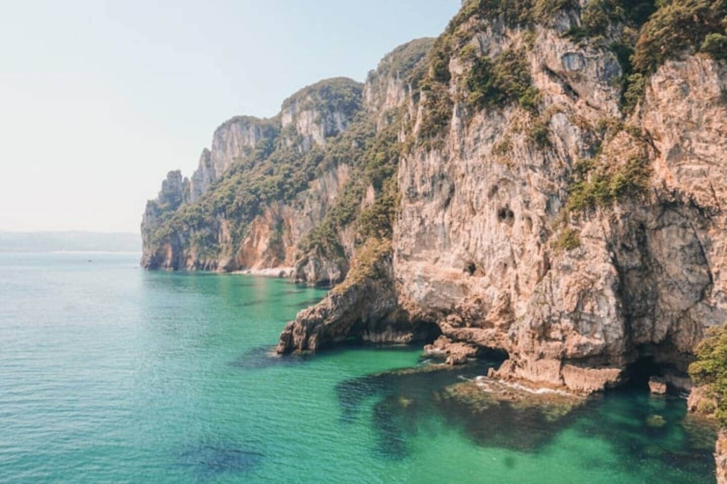 Un paisaje costero con acantilados rocosos y aguas turquesas cristalinas.