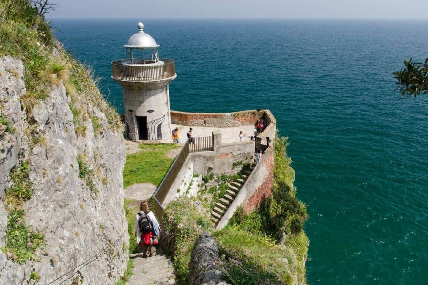 A lighthouse with a spiral staircase leading up to it, overlooking a body of water.