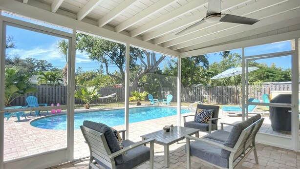 A covered patio with a pool, outdoor furniture, and a view of the backyard. - Sunshine House - charming 2 bedroom close to Downtown and the Legacy Trail. (Sarasota)