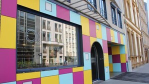 A colorful hotel facade with a large window and an arched entrance. - DOMUS HOTEL (Luxembourg City)