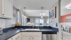 Una cucina moderna con lavastoviglie integrata, un'ampia finestra e vista sull'oceano.