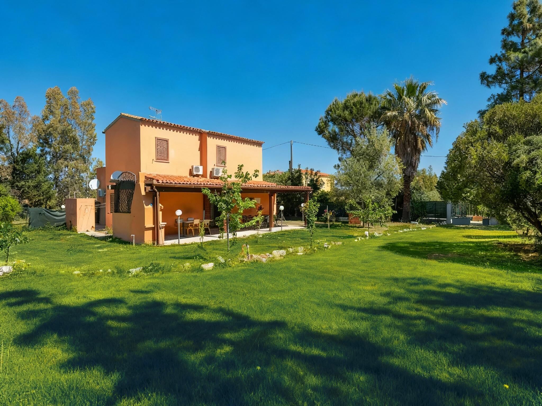 A two-story house with a patio and a well-maintained lawn.