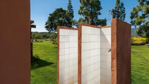 A modern outdoor shower with a tiled enclosure, set against a backdrop of a well-maintained lawn and trees. - Villa Giulietta - Castiadas (Castiadas)