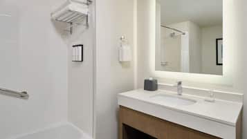 A modern bathroom with a bathtub, a sink with a mirror, and a towel rack.