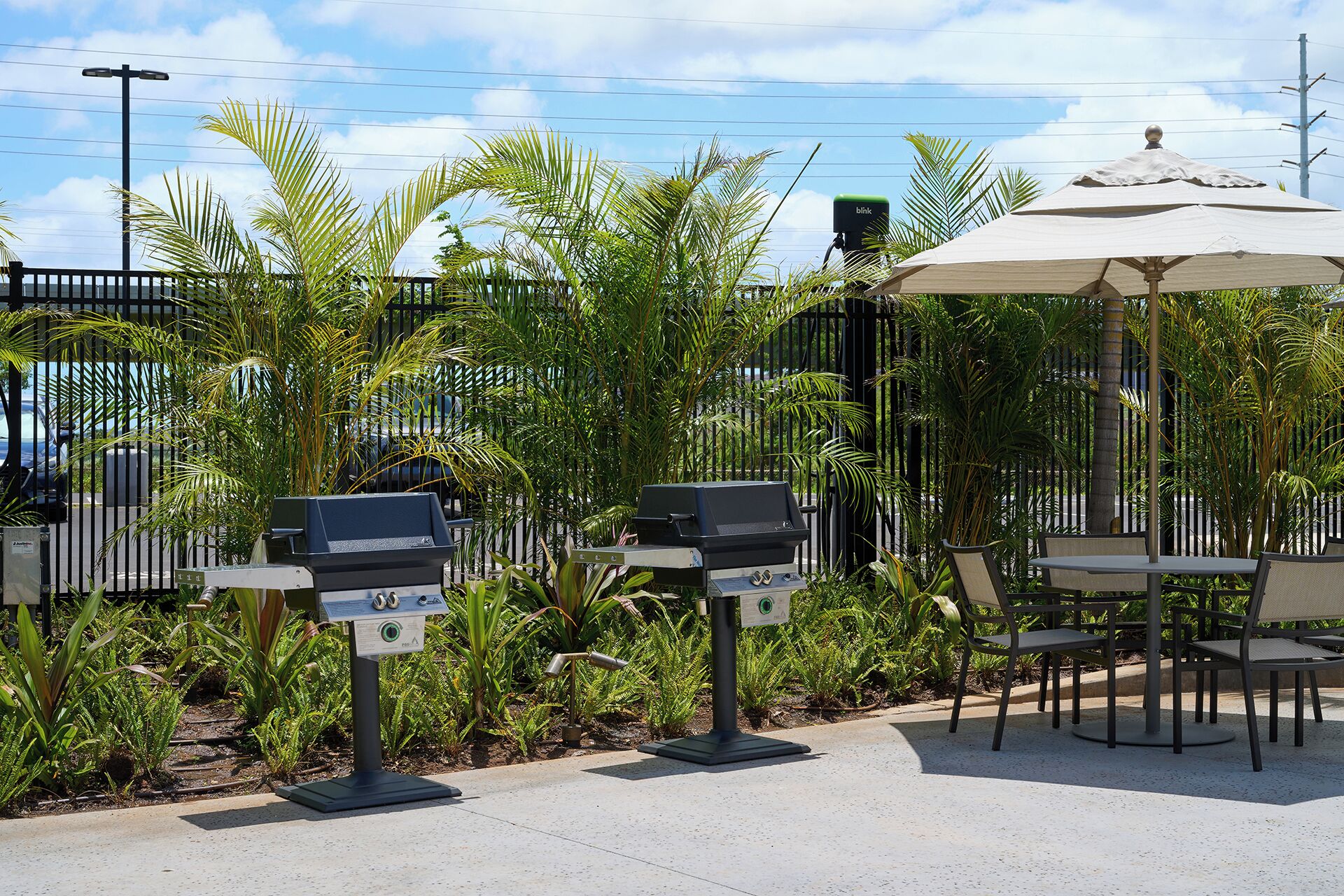 Outdoor seating with a grill, a table with chairs, and a gazebo.