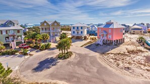 Zona residencial costera con casas que tienen balcones y una playa arenosa al fondo.