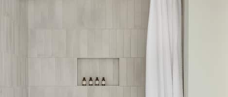 A bathroom with a bathtub, toilet, and a showerhead.