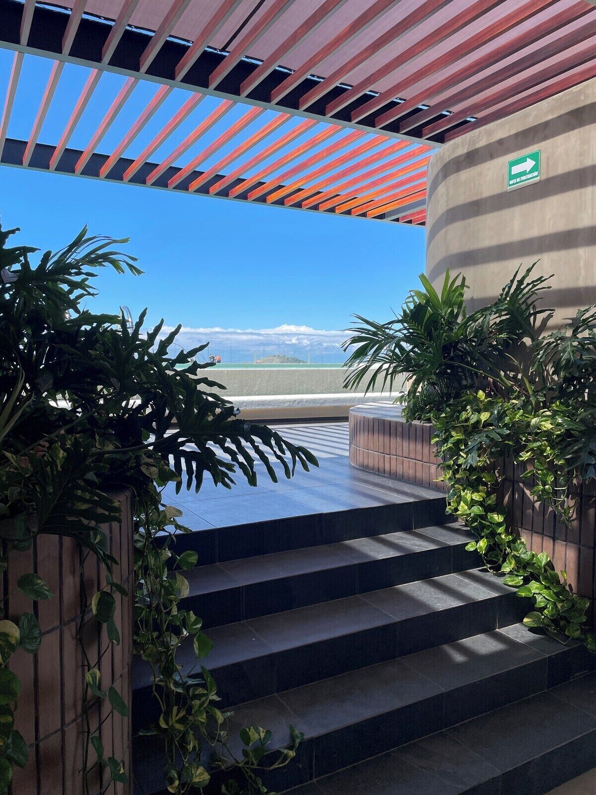 A staircase leading to a terrace with a view of a mountain range.
