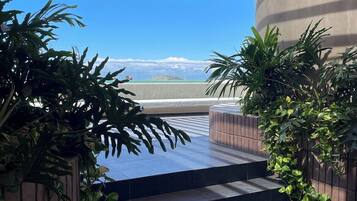 A staircase leading to a terrace with a view of a mountain range.