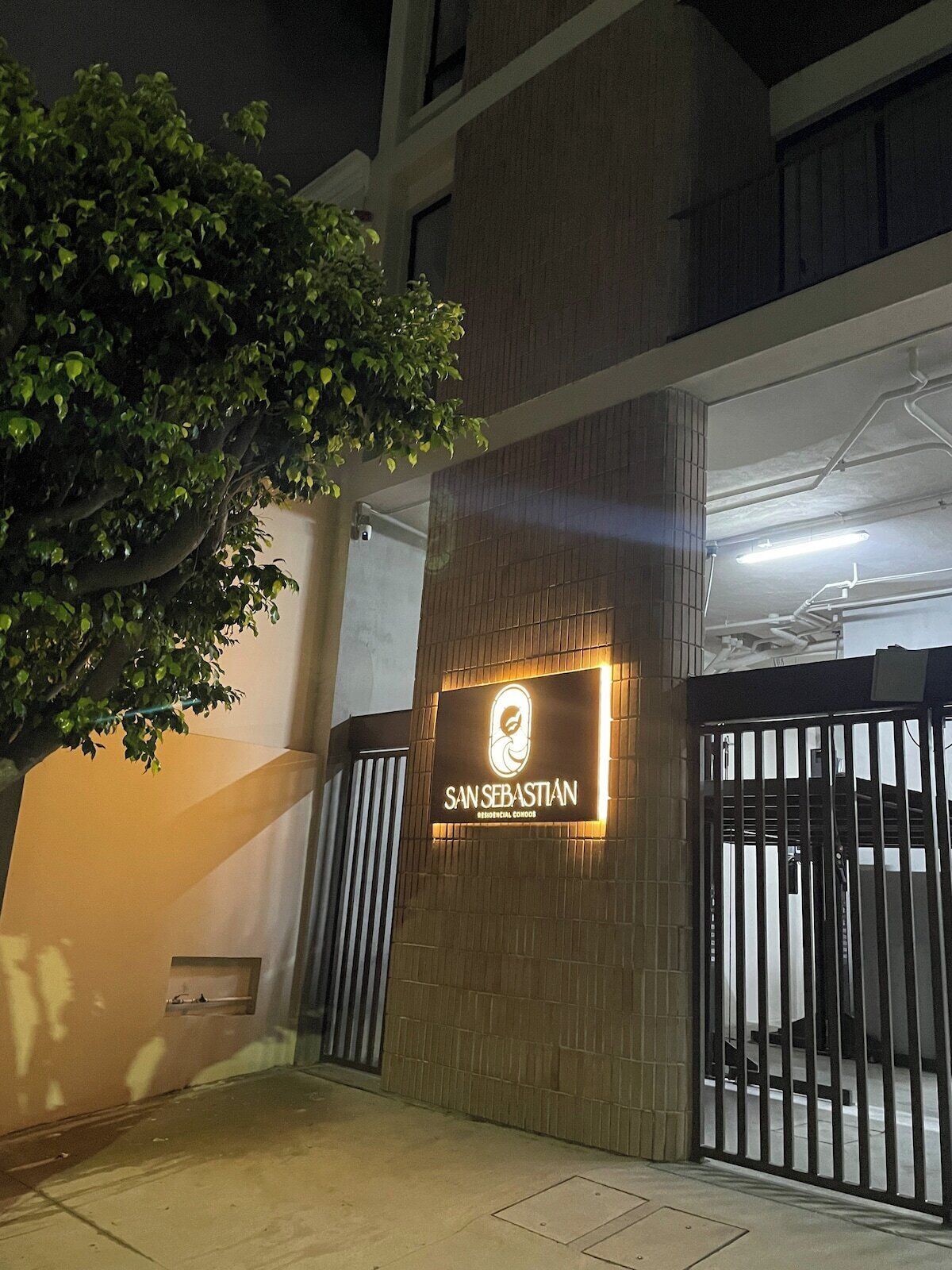A building entrance with a sign reading "SANSEBASTIAN RESIDENCIAL CONDOMINIUM".